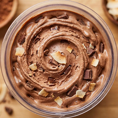 Island Fudge Ninja Creami recipe made with CRUSHS chocolate protein ice cream mix, chocolate chunks, and toasted coconut flakes