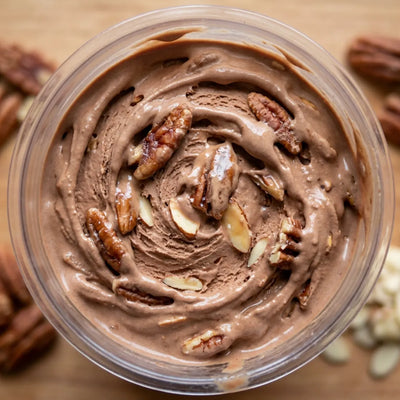 Praline Pecan Crunch Ninja Creami protein ice cream with praline pecans and sliced almonds folded into a chocolate base.