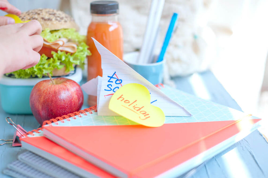 A desk setup with healthy snacks a water bottle and sticky notes representing the food environment changes that support getting ready for summer health goals through small daily decisions.