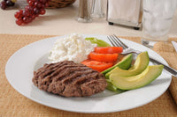 A plate of high protein foods including a burger patty cottage cheese avocado and vegetables representing practical GLP-1 protein tips for hitting daily protein targets when full meals feel difficult to finish.