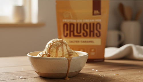 A creamy scoop of salted caramel ice cream in a bowl with a CRUSHS Protein Ice Cream Mix bag visible behind it representing the easiest high protein dessert ideas for Ninja Creami owners.
