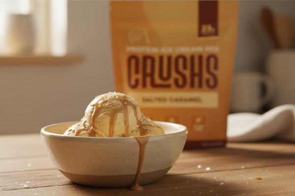 A creamy scoop of salted caramel ice cream in a bowl with a CRUSHS Protein Ice Cream Mix bag visible behind it representing the easiest high protein dessert ideas for Ninja Creami owners.