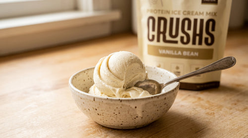 A creamy scoop of vanilla protein ice cream in a speckled ceramic bowl with a CRUSHS Vanilla Protein Ice Cream Mix bag visible behind it representing one of the most practical high protein desserts for GLP-1 users who still have sweet cravings.