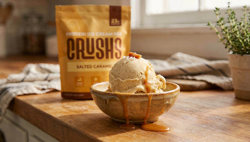 A creamy scoop of salted caramel protein ice cream in a ceramic bowl with a CRUSHS Salted Caramel Protein Ice Cream Mix bag visible behind it representing the answer to is protein ice cream healthy when the ingredients are right.