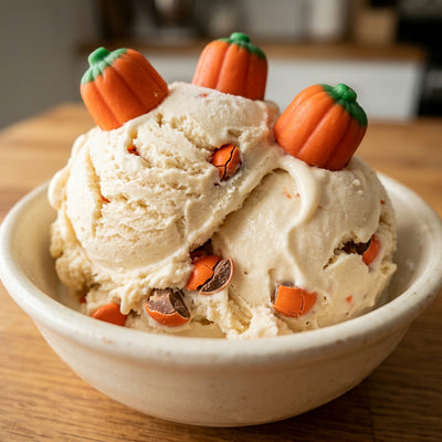 Jack-o'-Lantern Ninja Creami recipe made with CRUSHS vanilla protein ice cream mix, orange candy-coated chocolates, and candy pumpkins.