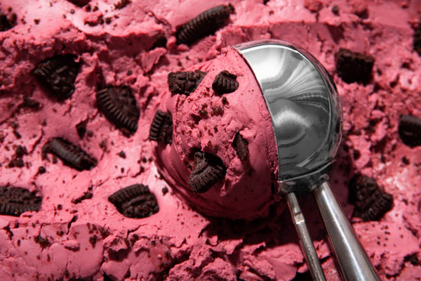  A close-up of a strawberry ice cream scoop with cookie pieces showing the rich indulgent texture of regular ice cream in the protein ice cream vs regular ice cream comparison.