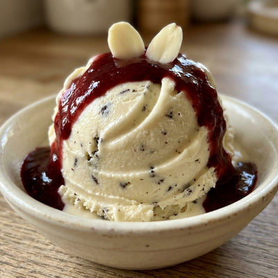 Vampire Bite Ninja Creami recipe made with CRUSHS vanilla protein ice cream mix, dark chocolate chips, raspberry sauce, and sliced almond fangs.