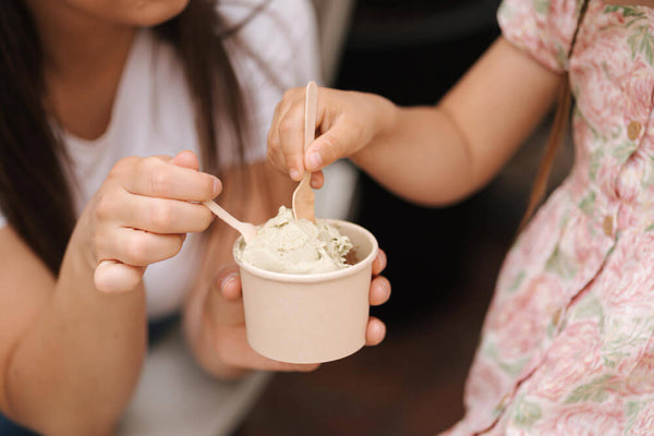 A mother and daughter sharing a bowl of homemade ice cream, enjoying clean ingredients like tara gum together