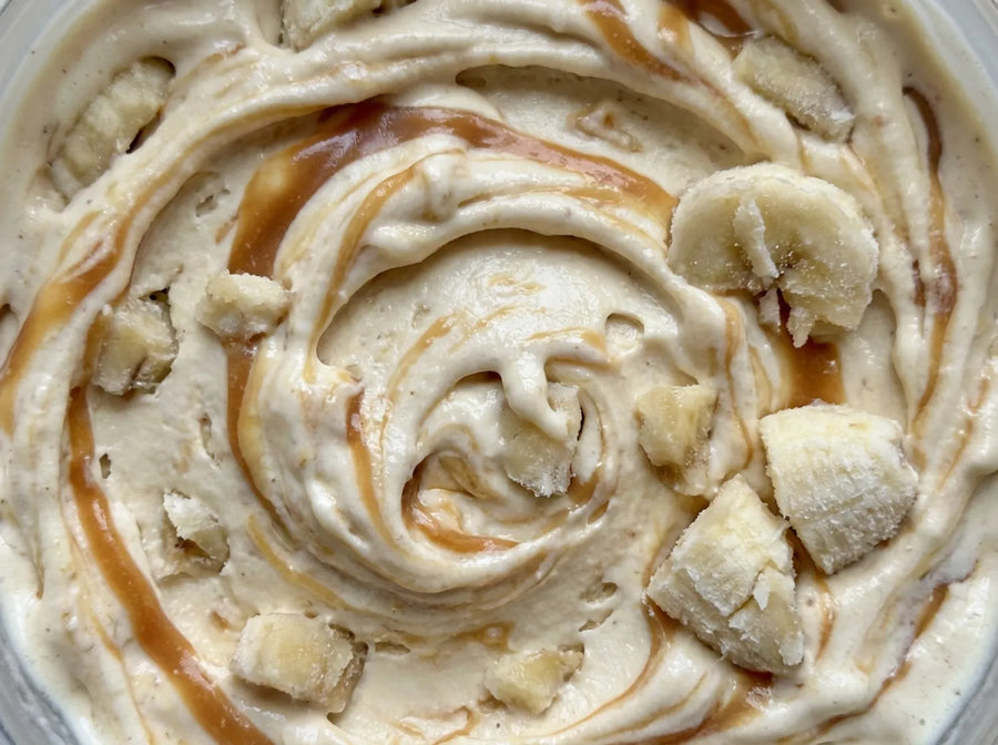 Bananas foster Ninja Creami ice cream with caramel ribbons swirled into a pint