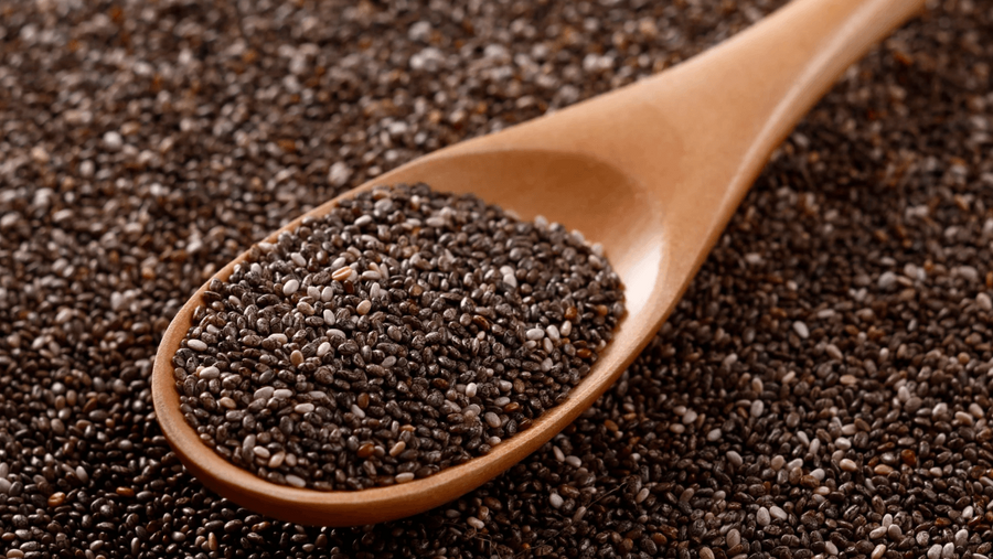 A small bowl of chia seeds on a wooden surface representing one of the most popular healthy mix ins for protein ice cream made in a Ninja Creami.
