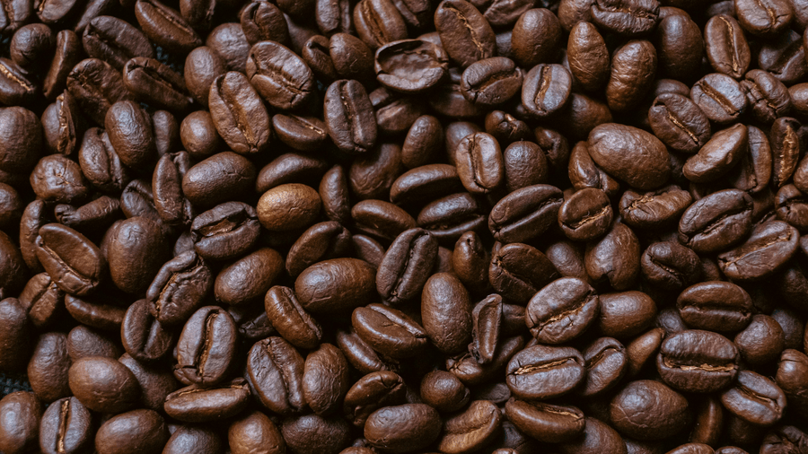 Dark roast coffee beans close up showing how roast level affects how much caffeine per cup you actually get.
