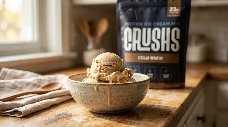 A creamy scoop of cold brew protein ice cream in a speckled ceramic bowl with a CRUSHS Cold Brew Protein Ice Cream Mix bag visible behind it showing a sweet cold protein option that works well for hitting protein on GLP-1 when appetite is low.
