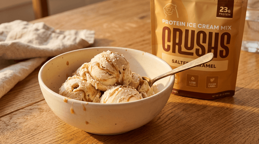 Two scoops of salted caramel protein ice cream in a ceramic bowl with a CRUSHS Salted Caramel Protein Ice Cream Mix bag visible behind it representing one of the best high protein snacks for summer that satisfies a sweet craving without the sugar spike.