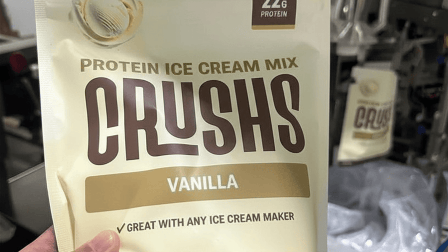 Someone holding a bag of CRUSHS Ninja Creami ice cream mix in the kitchen.