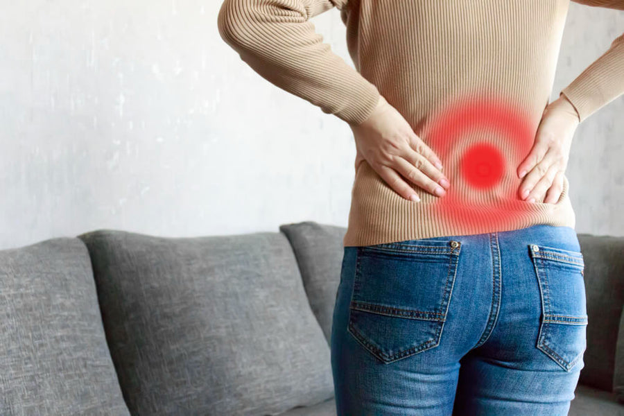  Person holding their lower back with a red inflammation indicator, representing low-grade inflammation as a cause of poor sleep quality