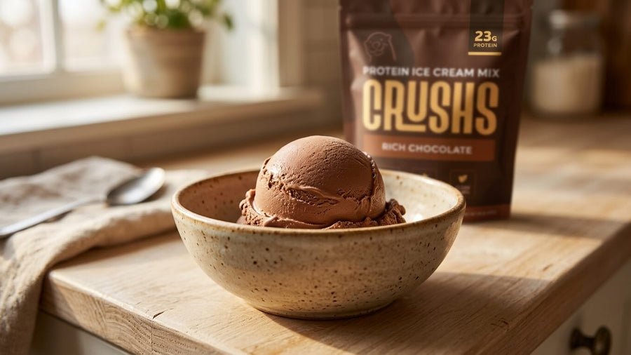 A creamy smooth scoop of rich chocolate protein ice cream in a rustic ceramic bowl with a CRUSHS Protein Ice Cream Mix bag visible in the background showing what the texture looks like when the ninja creami too crumbly problem is fully solved.