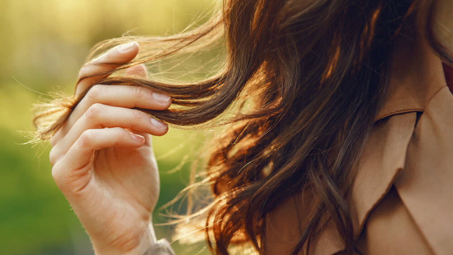 A close-up of a woman's healthy shiny hair showing one of the visible benefits of adequate daily protein intake for people asking do i need protein if i dont exercise.