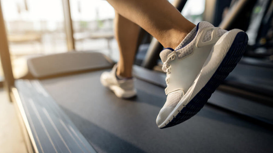 A person's torso and legs visible running fast on a treadmill representing the fitness nutrition mistake of treating cardio as a free pass to cancel out what you eat.