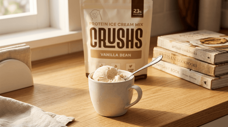 CRUSHS Vanilla Bean protein ice cream mix bag next to a cup of vanilla ice cream with a spoon.