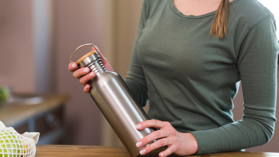Woman holding a sleek stainless steel water bottle as a practical Mother's Day gift for health conscious moms.