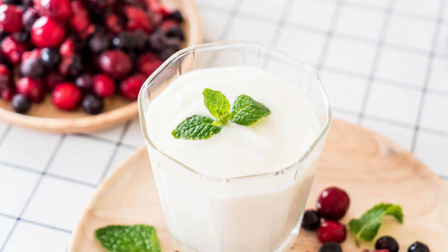 A glass of yogurt with fresh berries and mint beside it representing a cold light protein option that stays tolerable for hitting protein on GLP-1 when heavier foods feel like too much.