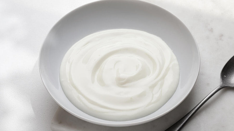 A plain bowl of smooth white greek yogurt representing one of the best cold and light GLP-1 protein tips for getting dairy protein in when appetite is heavily suppressed.